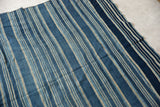 Detail of the vintage indigo cloth's varied blue and light striped, hand-woven texture.