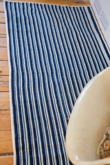 Hand-woven indigo blue and off-white striped textile showing vintage texture.