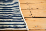 Hand-woven vintage indigo blue striped runner's cream side edge.