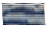 Finished bottom edge and corner of a hand-woven indigo striped textile.