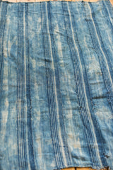 Close-up of hand-woven indigo throw, showcasing faded blue stripes and beautiful aged cotton patina.