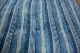 Indigo blue striped hand-woven African textile, showcasing varying stripe patterns and storied texture.