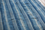 Hand-woven indigo blue textile, showing textured stripes and vintage character.