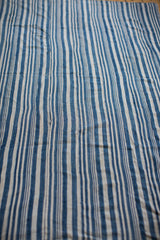 Vintage hand-woven indigo blue and natural white striped cotton textile texture.