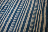Visible hand-woven texture and variations in indigo blue striped collectible textile.