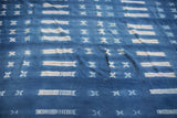 Textured blue and white resist patterns on a vintage indigo cotton textile.