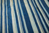 Vintage hand-woven African indigo throw with striped patterns and subtle texture.