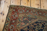 Secure dark edge and worn fringe on a vintage Heriz rug, with terracotta and navy motifs.