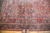 Distressed antique Persian Mahal carpet: rusty orange allover floral field and bold navy border.