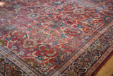 Distressed antique Persian Mahal carpet, rusty orange field, blue florals, visible knot heads.