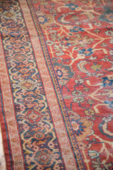 Distressed texture and intricate blue border of an antique Persian Mahal carpet.