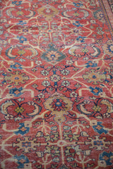 Distressed texture of an antique Mahal carpet, with rusty orange, blue, and gold motifs.
