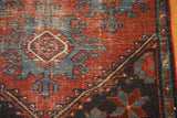 Distressed corner of antique Mehrevan rug with large geometric palmettes in deep burgundy, sky blue.