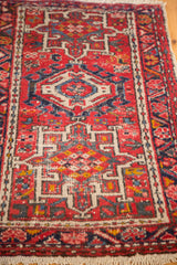 Bottom corner of vintage Karaja rug, red, ivory, blue geometric patterns and fringe.