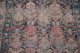 Repeating stylized boteh motifs and hand-knotted texture of the vintage Kurdish rug.