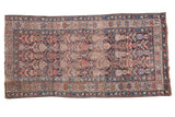 Vintage 1930s Kurdish rug featuring repeating boteh and geometric patterns in muted colors.
