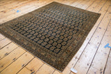 Corner view of antique Haji Jalili Tabriz rug, showing distressed fringe and boteh pattern.