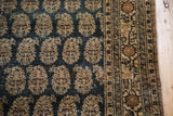 Persian Haji Jalili Tabriz rug detail, repeating tan boteh on distressed charcoal field.