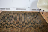 Distressed charcoal field featuring repeating boteh motifs on an antique Persian Tabriz rug.