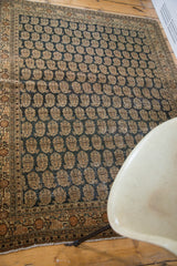 Storied wear on the repeating boteh pattern and unique charcoal field of this antique Tabriz.