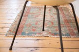 Antique Serapi rug fragment with powder blue, soft green, and terra cotta geometric patterns.