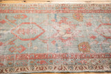 Antique Persian Serapi rug fragment displaying time-softened aqua blue field, geometric terra cotta motifs.