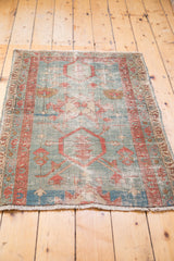 Antique Serapi rug's secured fringe and patinated aqua field with a terra cotta border.