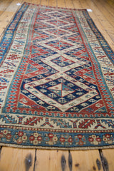 Distressed antique Bidjar runner detail showing geometric Caucasian pattern in blue, red, and cream.