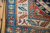 Distressed geometric borders in red, blue, and cream on an antique Kurdish Bijar rug runner.