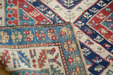 Folded detail of an antique Kurdish Bijar rug, highlighting geometric Caucasian patterns and colorful border.