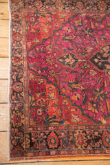 Dark floral border with ruby and orange accents, revealing fringe of a Farahan Sarouk.