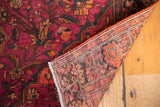 Finely knotted back of a vintage Farahan Sarouk rug with ruby magenta floral pile and fringe.