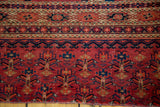 Antique Turkmen Chuval rug section with cranberry red field, geometric flower motifs, and intricate borders.