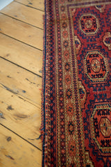 Antique Turkmen rug showcasing intricate geometric borders in cranberry red and navy blue.