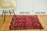 Vibrant magenta vintage Turkmen rug with fine weave and intricate Bokhara guls.