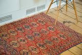 Antique Turkmen rug with repeating elephant footprint guls in cranberry, navy, and ivory tones.