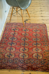 Intricate elephant footprint guls in cranberry, navy, and ivory tones on antique Turkmen rug.