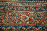 Distressed aesthetic of antique Fereghan carpet, showcasing geometric patterns in madder red and rich indigo.