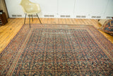 Antique Fereghan carpet with distressed indigo field and intricate madder red borders.
