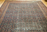 Distressed dark indigo field of antique Fereghan carpet, with intricate floral motifs and wear.