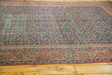 Antique Fereghan carpet's distressed indigo field, detailed border, and varied madder red tones.