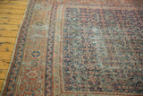 Antique Fereghan carpet showing its distressed indigo blue field and worn madder red motifs.