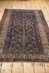 Antique Hamadan rug close-up: Herati field with bird motifs, antique ivory Serbend border, fringe.