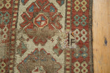Distressed geometric patterns and visible foundation on an antique Kazak rug.