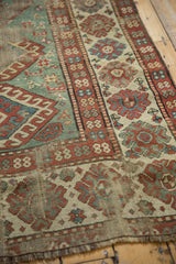 Distressed wide border and rare light green field detail on antique Kazak rug.