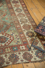 Detail of the antique Kazak rug's distressed wide border and rare light green field.