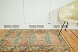Antique Caucasian Avar rug with distressed edge and faded rose, blue geometric patterns.