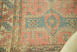 Antique Avar rug's geometric pattern in softened rose, pale blue, and cream hues.