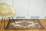 Vintage Sarouk rug's ornate central medallion, fine weave, and tropical florals on rare ivory.