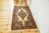 Vintage Sarouk runner's ivory field subtly changing color, bordered by vibrant floral motifs.